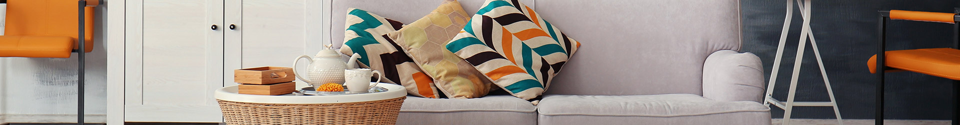 Simulador de hipotecas - Salón de casa con un sofá blanco y cojines estampados, y una mesita de café Simulador de hipotecas - Salón de casa con un sofá blanco y cojines estampados, y una mesita de café