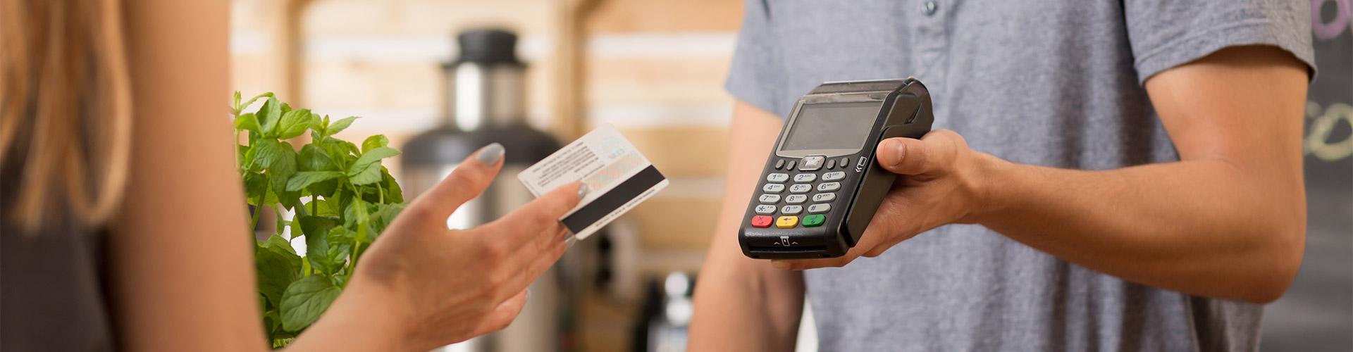 Ruralvía TPV Móvil - Mujer joven pagando con su tarjeta de crédito en un tpv en un comercio